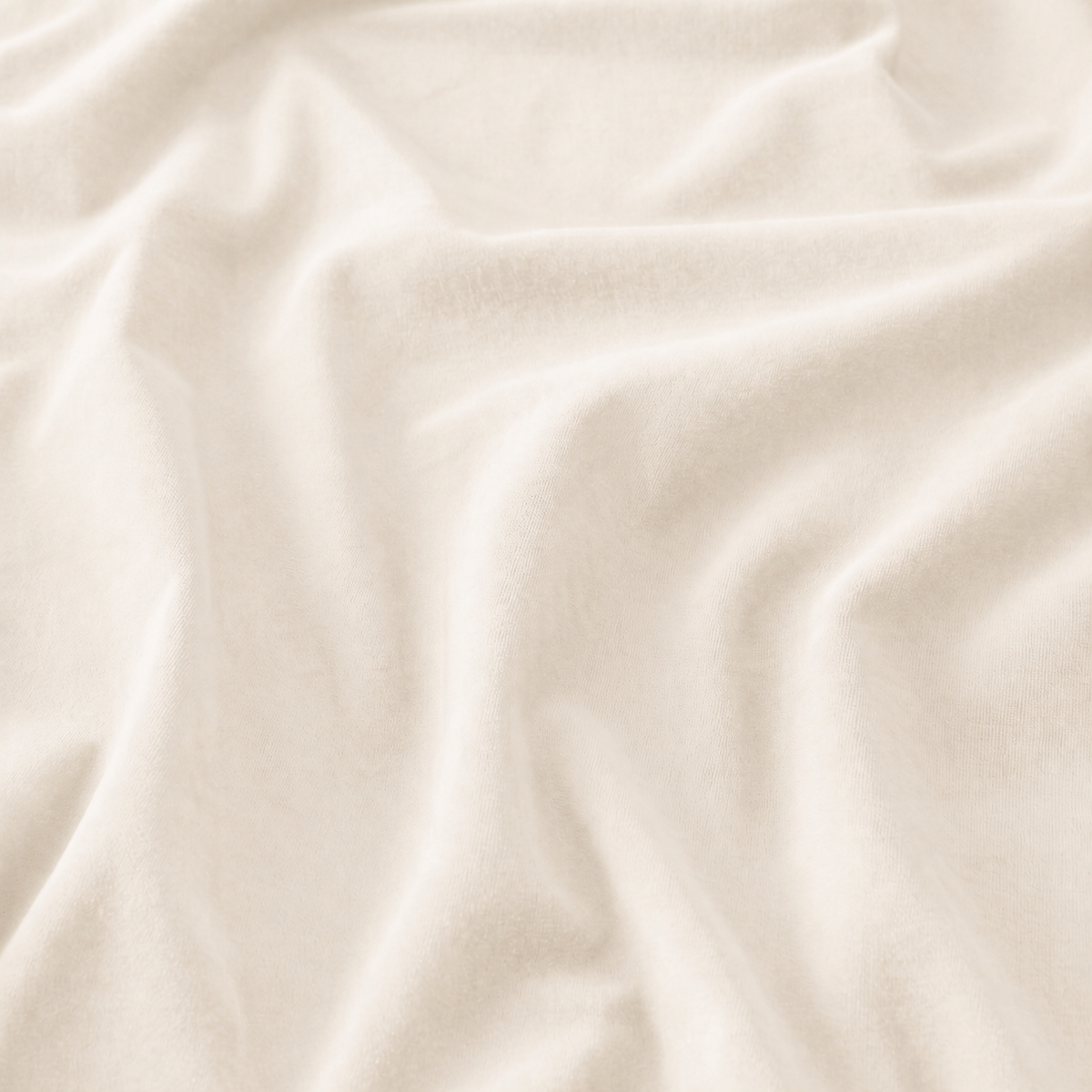 Close-up of cream velvet curtain fabric showing gentle folds and soft pile
