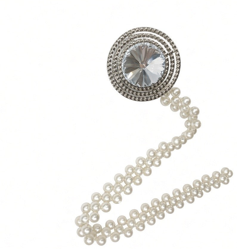 Two crystal and pearl curtain tiebacks holding cream curtain panels either side of a window
