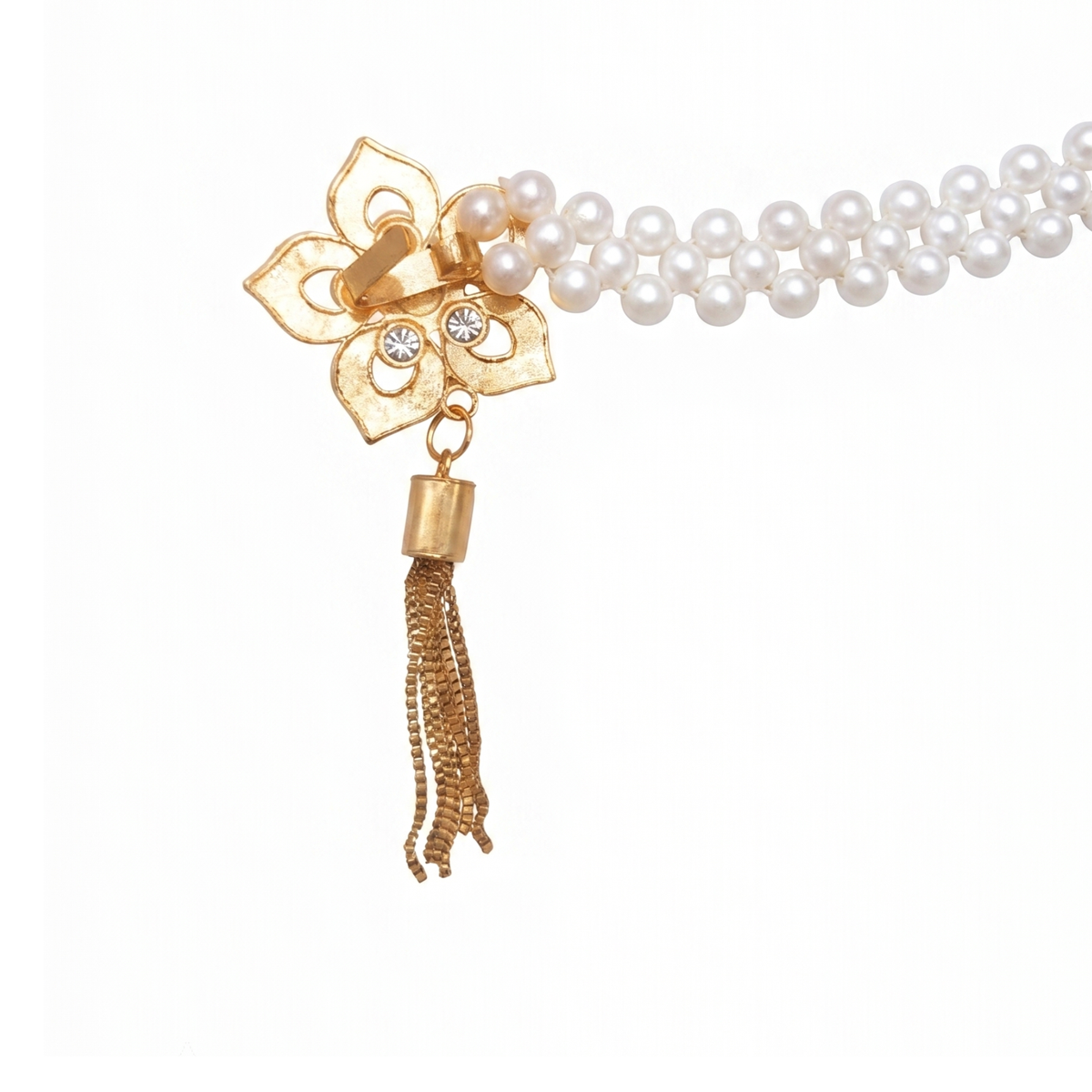 Angled close-up of a floral gold curtain tieback medallion with crystal Centre and chain tassel