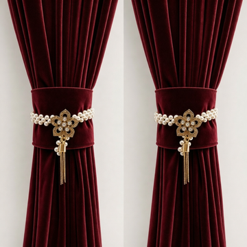 Two floral crystal and pearl curtain tiebacks gathering deep red velvet curtains either side of a window