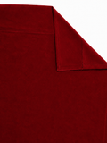 Close-up of maroon velvet curtain fabric showing rich folds and plush sheen
