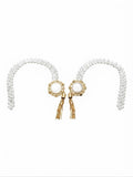 Two opalescent and pearl curtain tiebacks laid on white, each with a gold medallion and chain tassel