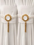 Two opalescent pearl curtain tiebacks gathering white curtain panels either side of a window