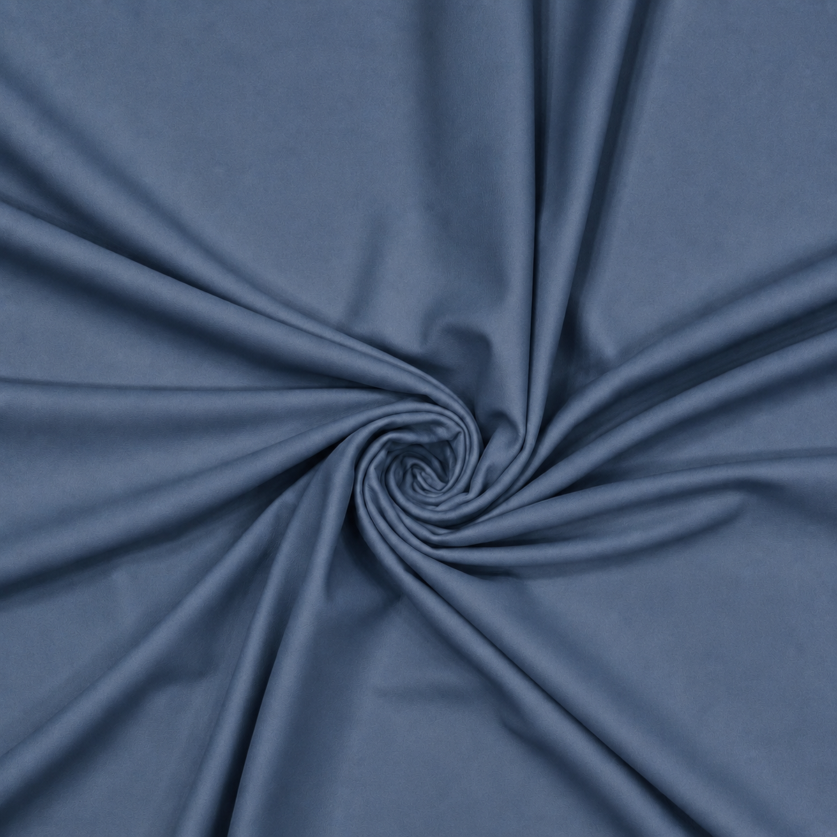Slate blue plain velvet curtain fabric arranged in a swirl showing its smooth drape
