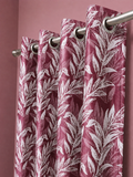 Wine floral curtain panel hanging from a steel rod on silver eyelets against a pink wall