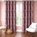 Wine floral curtains hung across a bright window in a pink living room with a white armchair and cane chair